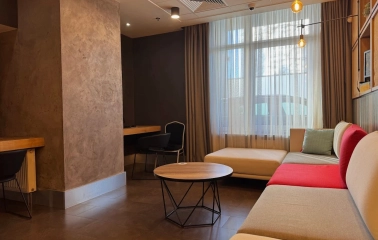Ibis Kyiv City Center in Kyiv - lounge area with beige sofa, round table and window