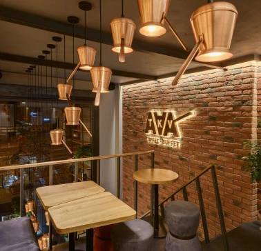 Takava in Kyiv - mezzanine seating with copper cezve lamps and brick wall logo