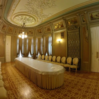 Budynok Horodetskoho in Kyiv - dining hall interior with a long table, tiled stove, and ornate ceiling