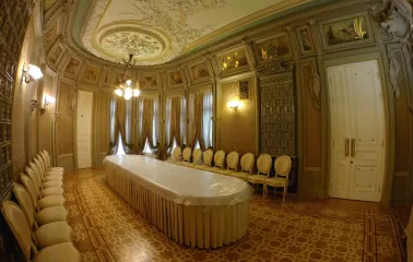 Budynok Horodetskoho in Kyiv - dining hall interior with a long table, tiled stove, and ornate ceiling