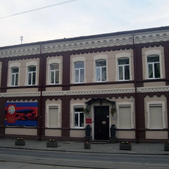 Muzei Suchasnoho Mystetstva in Kyiv - historic building facade combining maroon and beige brickwork with the museum signage near the entrance