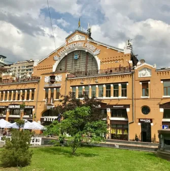 Facade of the Bessarabian Market in Kyiv with a terrace and summer tables