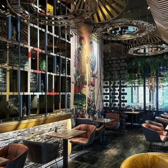 Restaurant Chary - large dining hall with a cultural mural and wire mesh screen dividers