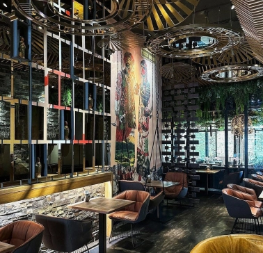 Restaurant Chary - large dining hall with a cultural mural and wire mesh screen dividers