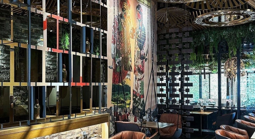 Restaurant Chary - large dining hall with a cultural mural and wire mesh screen dividers