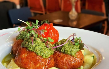 Restaurant Zigzag - meatballs topped with pesto and a roasted tomato on a plate
