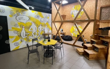 Muzei u Temriavi in Kyiv - modern waiting area designed with wooden structures and yellow accents featuring bean bag chairs for visitors