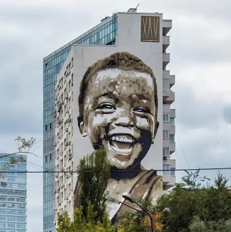 Simple happiness in Kyiv - fresco portrait of a boy - a massive portrait symbolizing joy in little things and hope