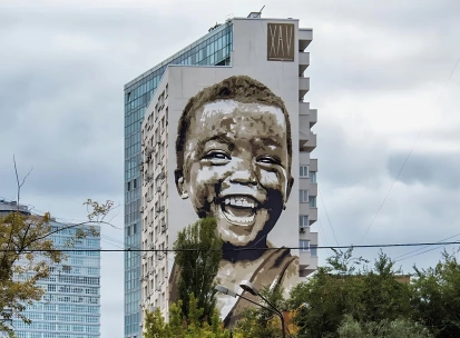 Simple happiness in Kyiv - fresco portrait of a boy - a massive portrait symbolizing joy in little things and hope