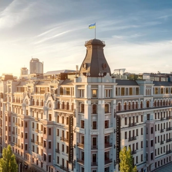 The facade of the Premier Palace Hotel in Kyiv with the Ukrainian flag on the roof