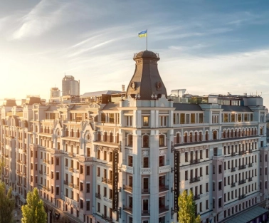 The facade of the Premier Palace Hotel in Kyiv with the Ukrainian flag on the roof