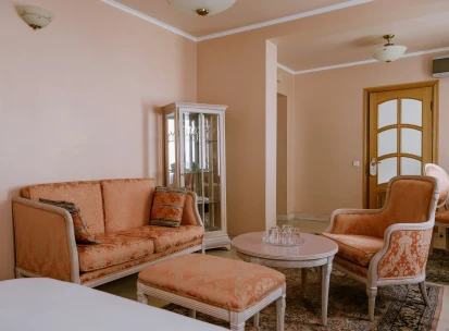 Vozdvyzhenskyi in Kyiv - classic interior with peach sofas and glass display cabinet