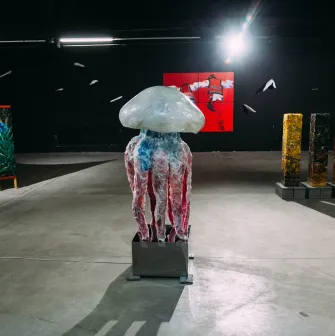 Lavra Gallery in Kyiv - large jellyfish sculpture standing in the center of a dark modern art hall