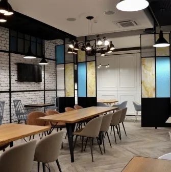 Honey in Kyiv - dining space with soft seats and colored glass partitions