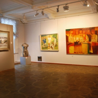 Kyivska Kartynna Halereia in Kyiv - spacious exhibition room with paintings, a torso sculpture and patterned parquet