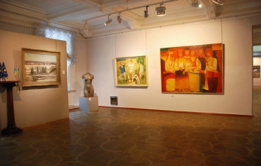 Kyivska Kartynna Halereia in Kyiv - spacious exhibition room with paintings, a torso sculpture and patterned parquet