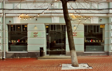 Svit Kavy in Kyiv - light blue cafe facade with large glass windows and tree