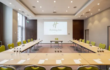 Office meeting room with a table and screen at Holiday Inn