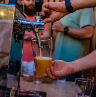A bartender pouring beer into a glass at the "Hvlv" bar in Podil, Kyiv