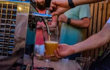 A bartender pouring beer into a glass at the "Hvlv" bar in Podil, Kyiv