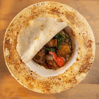 Seliam in Kyiv - bowl with meat stew covered by thin baked flatbread