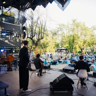 Vyava in Kyiv - outdoor concert stage with musicians performing for an audience sitting on blue bean bags in a park