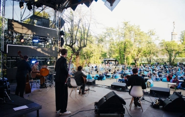 Vyava in Kyiv - outdoor concert stage with musicians performing for an audience sitting on blue bean bags in a park