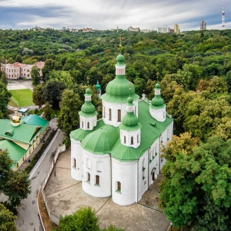 St. Cyril's Church in Kyiv - aerial view of white church with green domes among trees