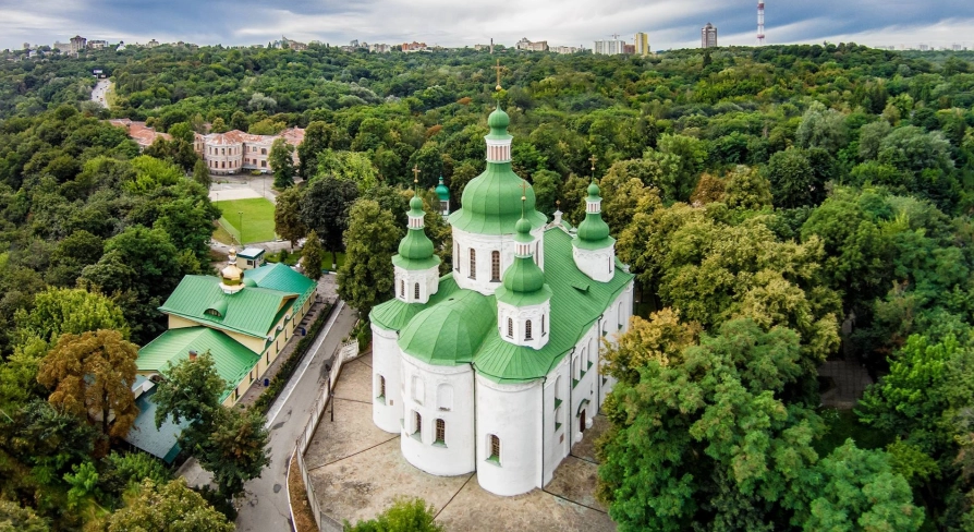 St. Cyril's Church in Kyiv - aerial view of white church with green domes among trees