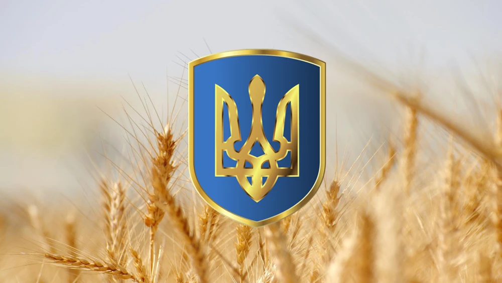 The golden state coat of arms of Ukraine against a wheat field