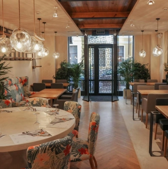 Restaurant Italiets iz Beiruta - bright dining room with large round tables and floral chairs