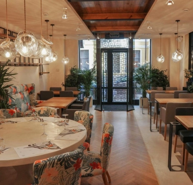 Restaurant Italiets iz Beiruta - bright dining room with large round tables and floral chairs