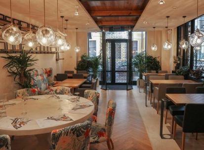 Restaurant Italiets iz Beiruta - bright dining room with large round tables and floral chairs