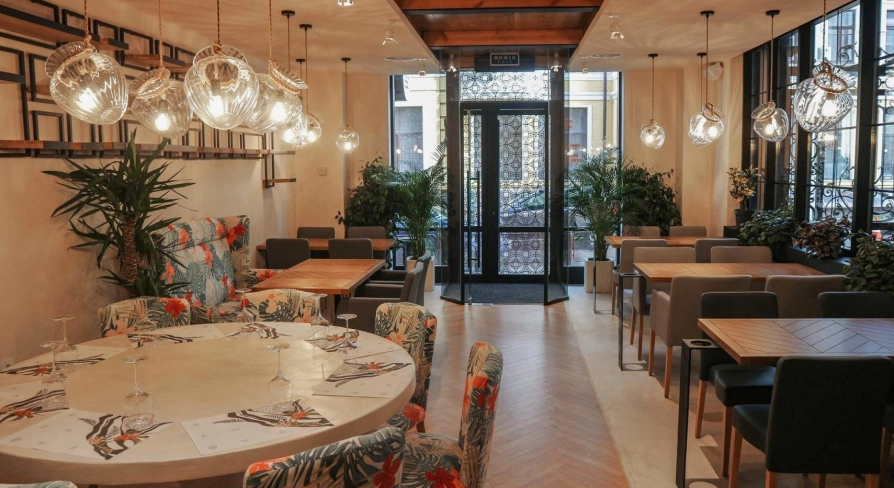 Restaurant Italiets iz Beiruta - bright dining room with large round tables and floral chairs