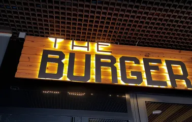 The Burger - illuminated restaurant sign on wooden panel