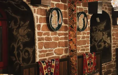 Sofra in Kyiv - cozy corner with brick walls, mirrors and traditional patterned cushions