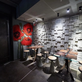 Restaurant Ostannia Barykada - small dining area with poppy flower art and a textured concrete wall