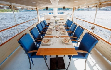 Restaurant Khutorets na Dnipri - table set for a meal on a river boat deck with blue chairs
