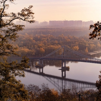 Dnipro river - pedestrian bridge to Trukhaniv Island framed by autumn trees