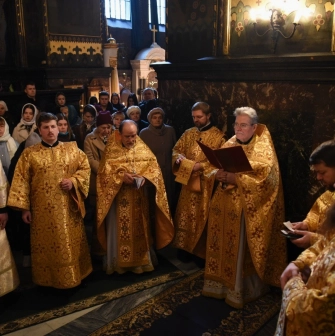 St. Volodymyr's Cathedral in Kyiv - group of priests in gold robes reading prayer books