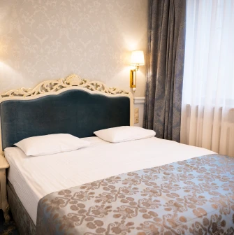 A classic deluxe bedroom with elegant furnishings at the Royal Olympic Hotel in Kyiv