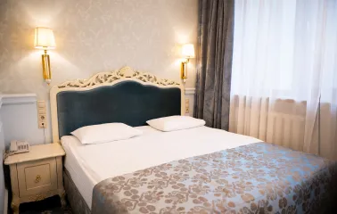 A classic deluxe bedroom with elegant furnishings at the Royal Olympic Hotel in Kyiv