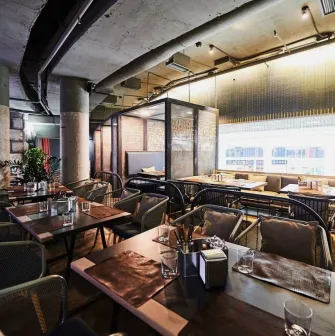 Restaurant Ostannia Barykada - main dining area with industrial design and banquette seating