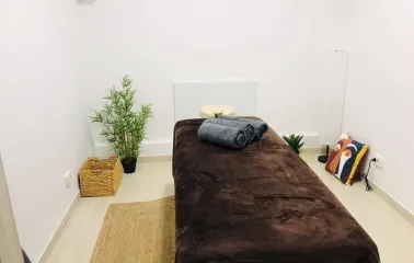 Brown massage couch with towels in Aura Spa room