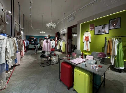 Kapsula in Kyiv - bright and spacious showroom interior with high ceilings and crystal chandeliers displaying racks of fashionable clothes and suitcases