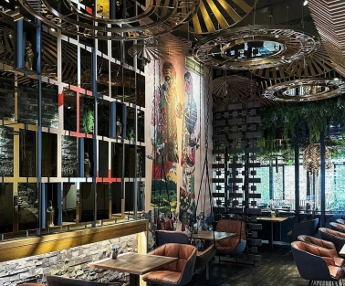 Restaurant Chary - large dining hall with a cultural mural and wire mesh screen dividers