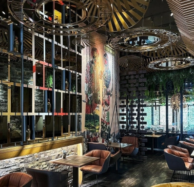 Restaurant Chary - large dining hall with a cultural mural and wire mesh screen dividers
