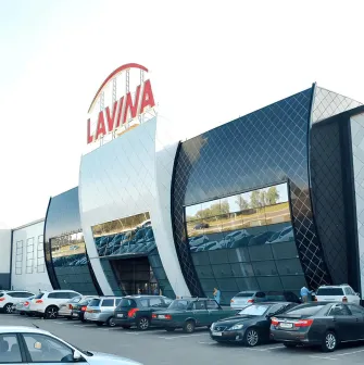 Main entrance to Lavina Mall featuring a large glass facade and parking