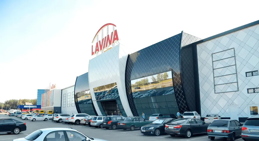Main entrance to Lavina Mall featuring a large glass facade and parking