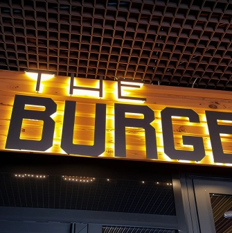 The Burger - illuminated restaurant sign on wooden panel